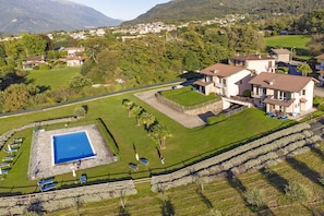 A residential area with houses, a swimming pool, and a well-maintained lawn. - Iris (Colico)