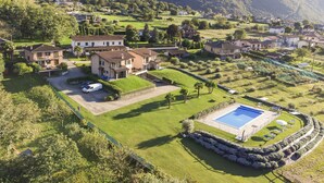 A residential area with houses, a swimming pool, and a well-maintained lawn. - Iris (Colico)