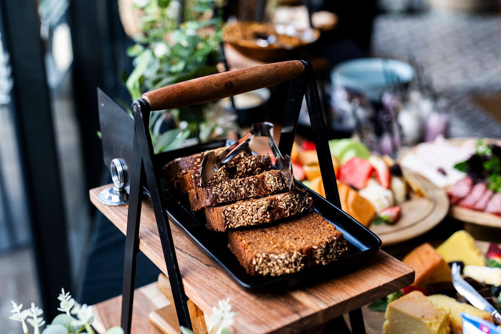 Eine Schale mit Granola-Riegeln auf einem Holztisch, im Hintergrund steht eine Pflanze.