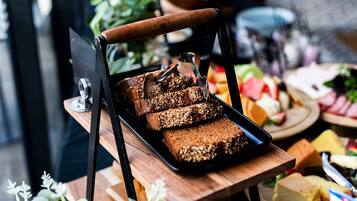 A tray of granola bars on a wooden table with a plant in the background.