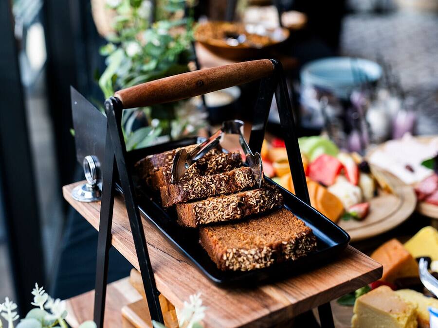 A tray of granola bars on a wooden table with a plant in the background.