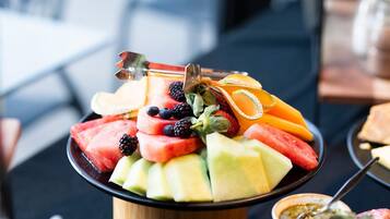 Una bandeja de frutas con sandía, melón, fresas, zarzamoras y naranjas.