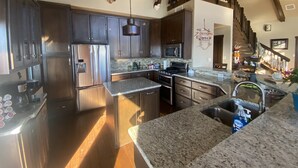 Una cocina moderna con electrodomésticos de acero inoxidable, encimeras de granito y una isla grande.