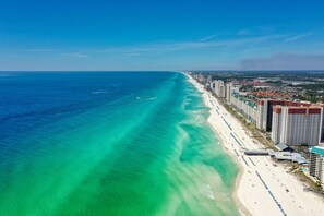 A coastal cityscape with a long beachfront, high-rise hotels, and clear blue waters. - STUNNING Beachfront Condo! Breathtaking Views! Pickleball Courts (Panama City Beach)