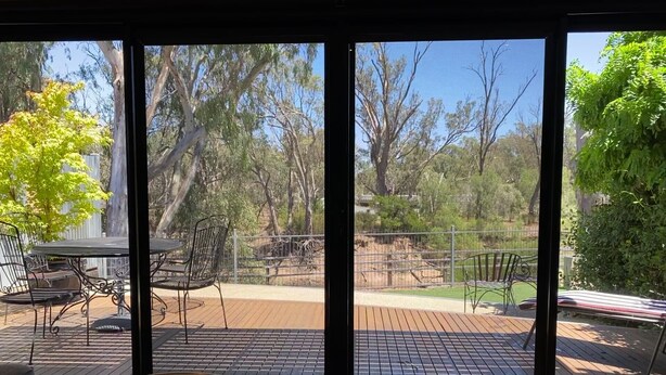 A room with a large sliding glass door leading to an outdoor deck with a table and chairs. - Adelphi 3 - River views located in the centre of Echuca (Echuca)