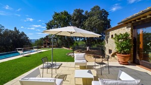 A patio with outdoor furniture, a swimming pool, and a stone building. - Paradiso Villas (Casole d'Elsa)