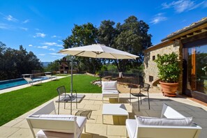 A patio with outdoor furniture, a swimming pool, and a stone building. - Paradiso Villas (Casole d'Elsa)