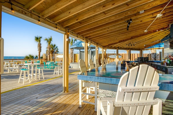 Enjoy ocean views from this outdoor deck with Adirondack chairs and dining tables.