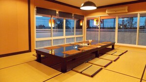 A traditional Japanese room with tatami mats, a low table, and sliding doors. - Eastpana Hotel (Si Racha)