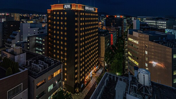 Un hotel de gran altura con varios pisos, un letrero visible en la parte superior y vistas del paisaje urbano circundante.