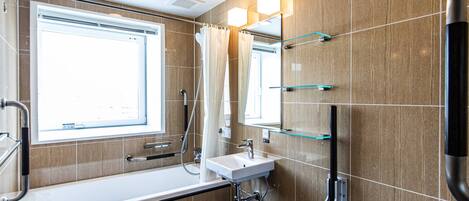 A modern bathroom with a bathtub, sink, and mirror.