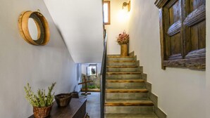 A staircase with a wooden handrail and a vase of flowers at the top.