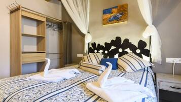 Une chambre à coucher avec un lit à baldaquin, une literie à rayures, une armoire en bois et un tableau accroché au mur.
