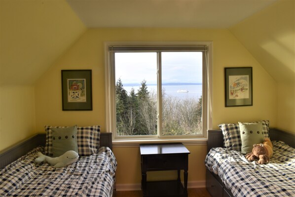 A bedroom with two beds, a window with a view of the sea, and framed pictures on the walls. - Amazing and serene view house, art deco charmer, fully restored (Seattle)