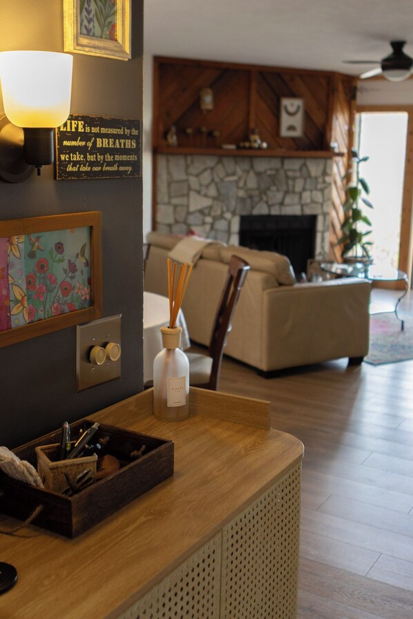 A living room with a wooden coffee table, a lamp, a fireplace, and a sofa.