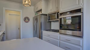 Een moderne keuken met witte kasten, roestvrijstalen apparatuur en een centraal eiland.