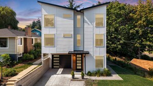 A modern two-story house with a flat roof, large windows, and a front porch. - Ruston Retreat: Sauna, ice bath, Modern 4B 4BA 
& Stunning Water View (Tacoma)
