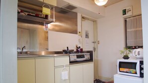 A compact kitchen with a stove, microwave, and sink. - suzuki4 (Tokyo)