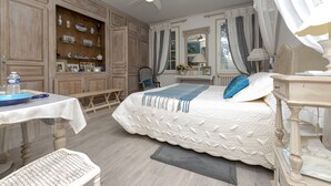 Un dormitorio con cama, escritorio, silla, armario y ventilador de techo.