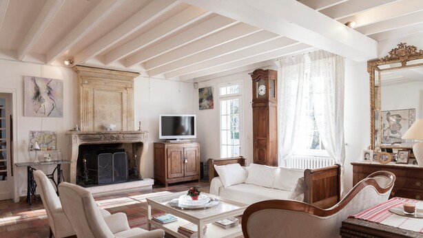 Un salón amplio con chimenea, televisor y un espejo grande.