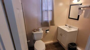 Un baño pequeño con inodoro, lavabo y espejo.