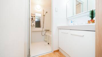 A bathroom with a shower, a toilet, and a sink.