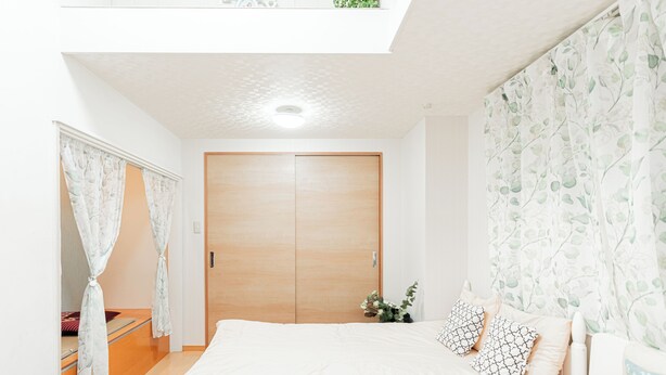 A bedroom with a large bed, a wooden wardrobe, and a skylight. - suzuki6 (Tokyo)