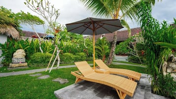 Una piscina al aire libre, sillones reclinables de piscina