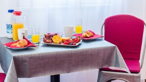 A breakfast table with croissants, fruit, and juice. - Miracle Apartments (Dubrovnik)