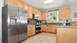 Una cocina moderna con electrodomésticos de acero inoxidable, armarios de madera y una isla grande.