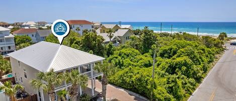 Uma área residencial costeira com uma casa que tem varanda coberta e vista para o mar.