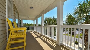 A covered porch with white railings and yellow chairs. - Spacious Coastal Home w/ Close Beach Access & Private Pool in Destin! 🌊🌴☀ (Destin)