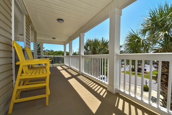 A covered porch with white railings and yellow chairs. - Spacious Coastal Home w/ Close Beach Access & Private Pool in Destin! 🌊🌴☀ (Destin)