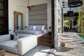 A modern bedroom with a bed, a sofa, and a large mirror. - Clay Beach Samui (Koh Samui)