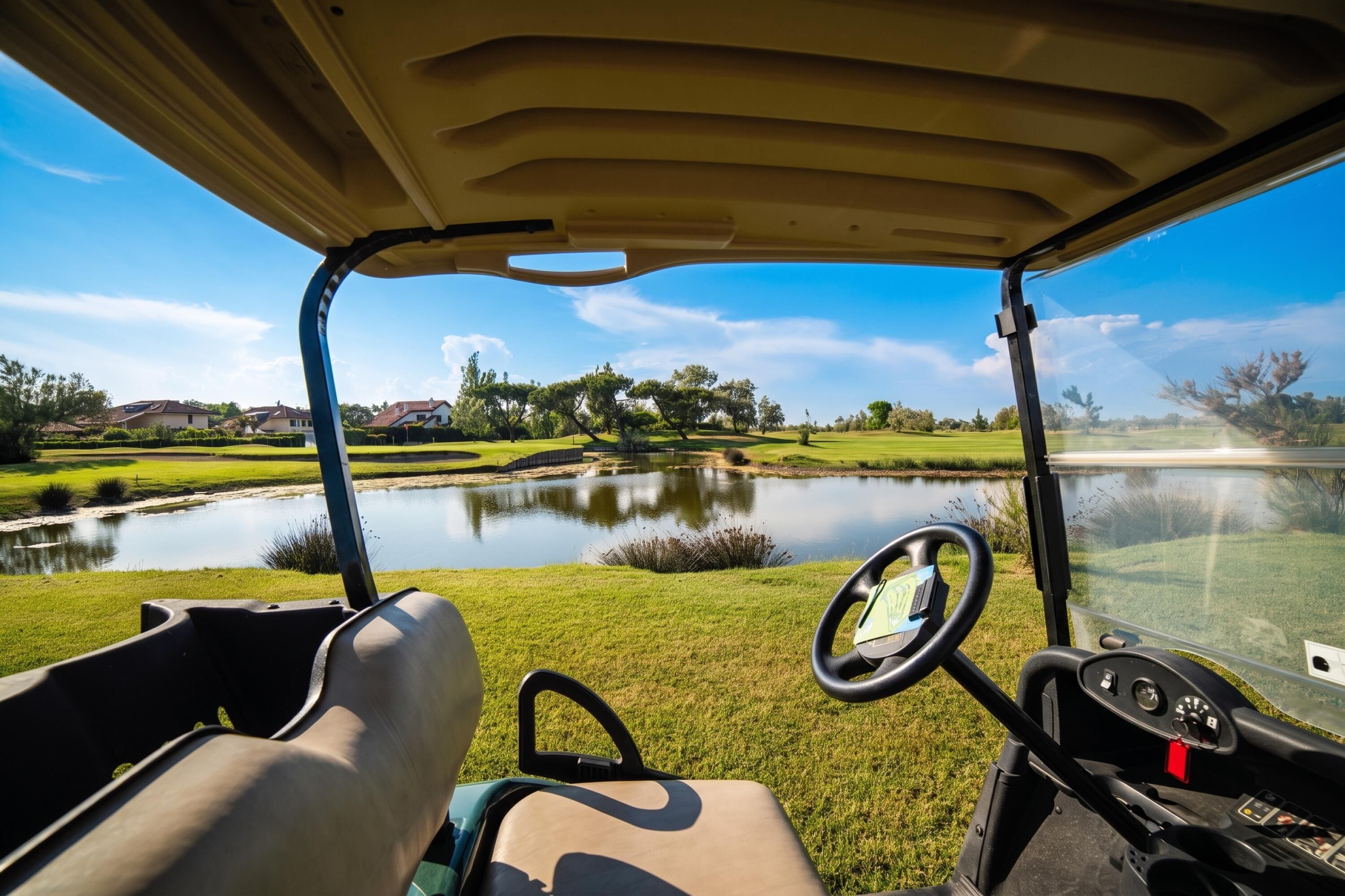 A golf cart interior with a steering wheel, dashboard, and seat.