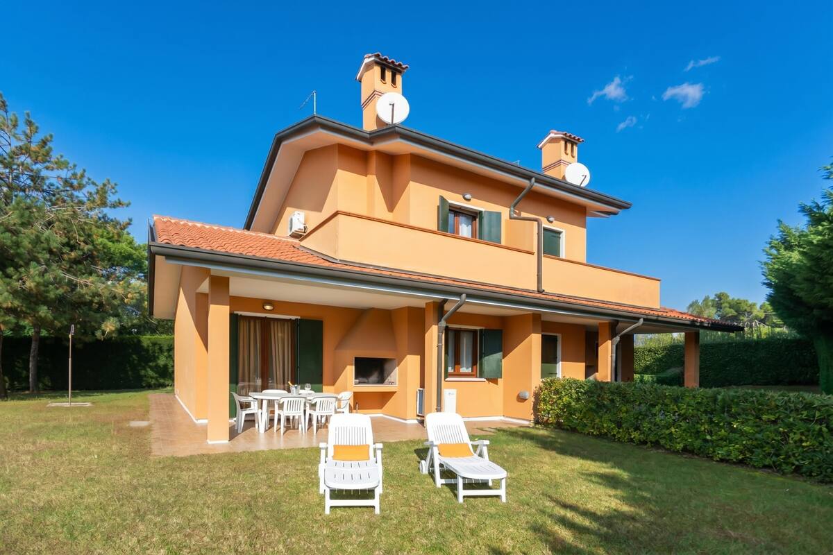 Une maison à deux étages dotée d’un patio, d’un espace salon extérieur et d’une cheminée.