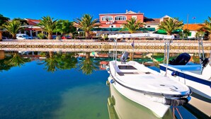 A marina with boats docked, clear water, and buildings in the background. - Family Friendly Pool House Ana Near Zadar (Bibinje)