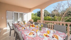 A dining table set with breakfast items, wicker chairs, and a view of greenery. - Family Friendly Pool House Ana Near Zadar (Bibinje)
