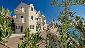 A stone building with balconies, a paved area, and a view of the sea. - Family Friendly Pool House Ana Near Zadar (Bibinje)