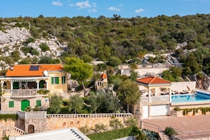 A coastal property with a swimming pool, stone walls, and a hillside view. - Pool Villa Vese /w Panoramic Sea View (Marina)
