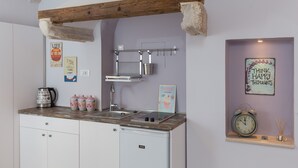 A compact kitchen with a wooden beam ceiling, a built-in sink, and a compact dishwasher. - Studio Apartment Lumia (Dubrovnik)