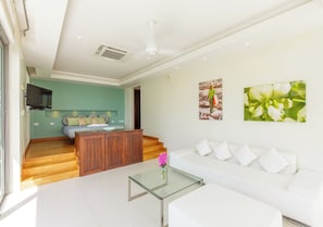 A modern living room with a white sofa, glass coffee table, and a wooden cabinet. - Baan Asan (Koh Samui)