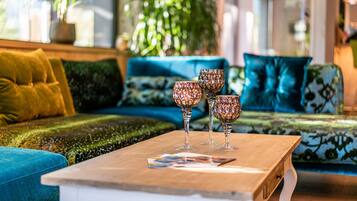 Ein gemütliches Wohnzimmer mit Couchtisch aus Holz, einem blauen Sofa und dekorativem Glaswaren.