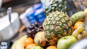 Una variedad de frutas, como piña, naranjas y manzanas.