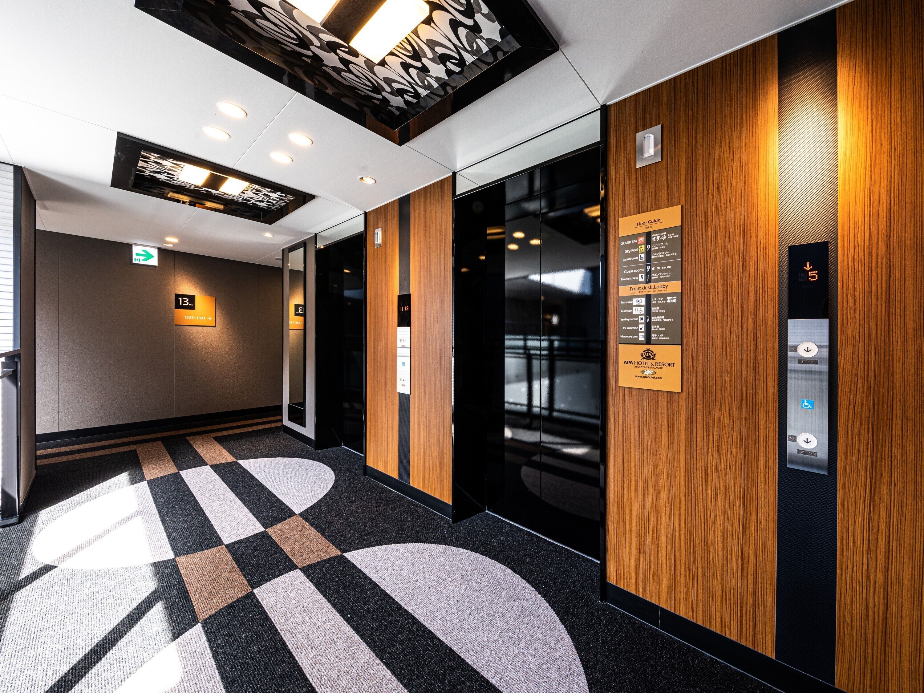 A modern elevator interior with a digital display, a floor guide sign, and a reception area with a check-in desk.
