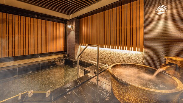 Un spa moderno con jacuzzi, paneles de madera y suelo de piedra.