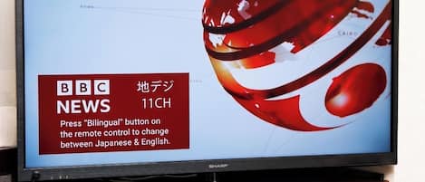 A television displaying BBC News 11CH with a red and white abstract design.