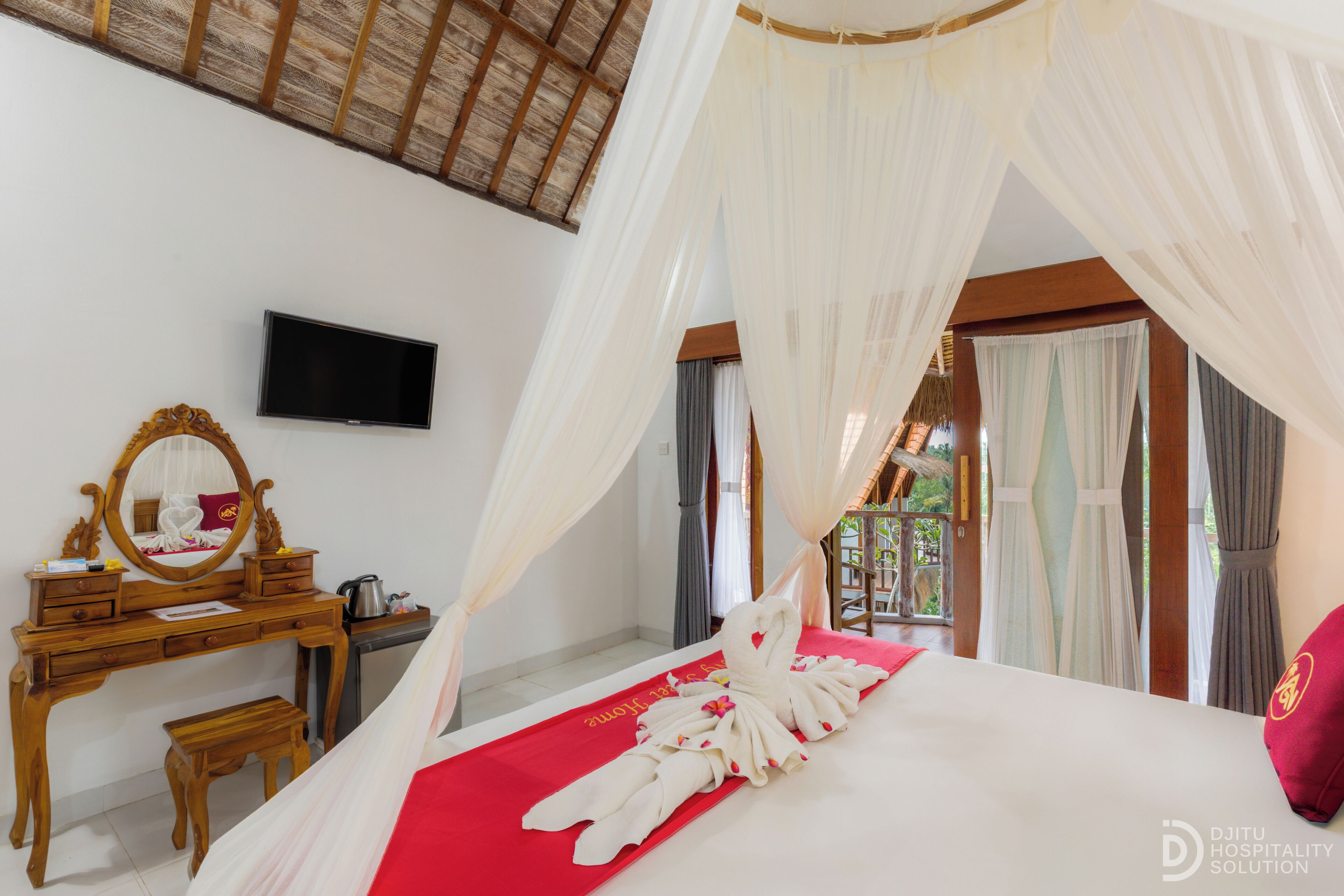 A bedroom with a canopy bed, a wooden dresser, a television, and a view of the outdoors.