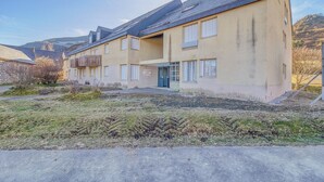 Un bâtiment à deux étages, doté d’un toit plat et d’un petit jardin à l’avant.