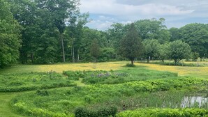 Un jardín ajardinado con varios macizos de plantas y una estatua.